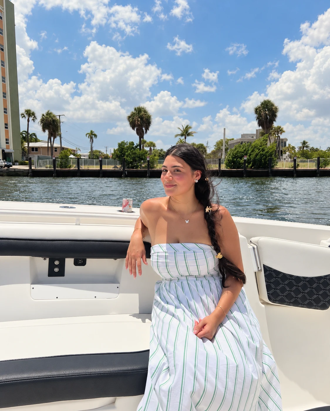 Sylvia Lee seated aboard the white boat beside the Florida waterfront