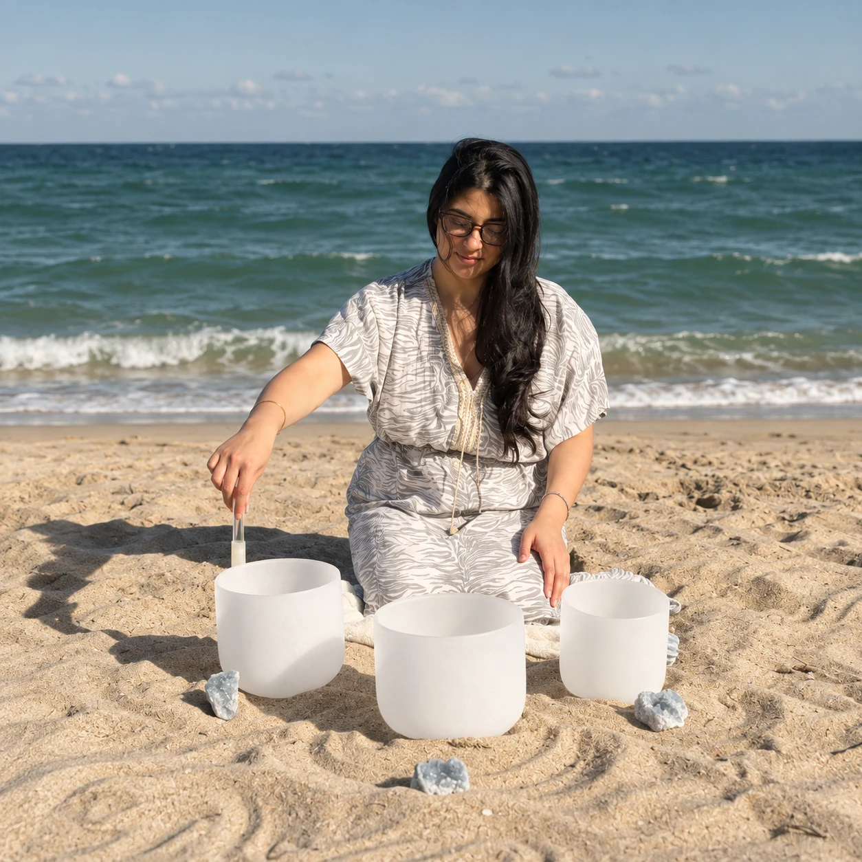 Sylvia Lee playing white singing bowls beside the sea